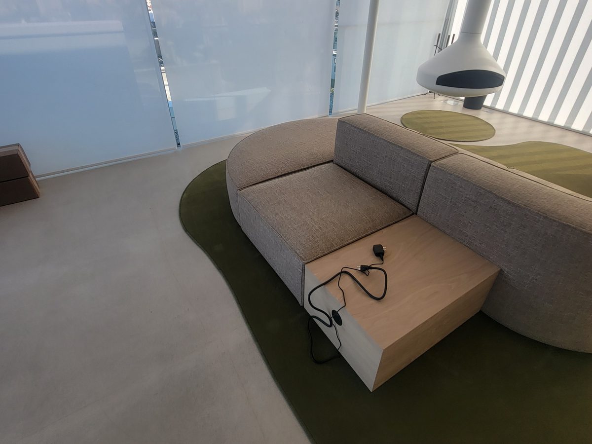 Custom-shaped green area rug under a curved sectional