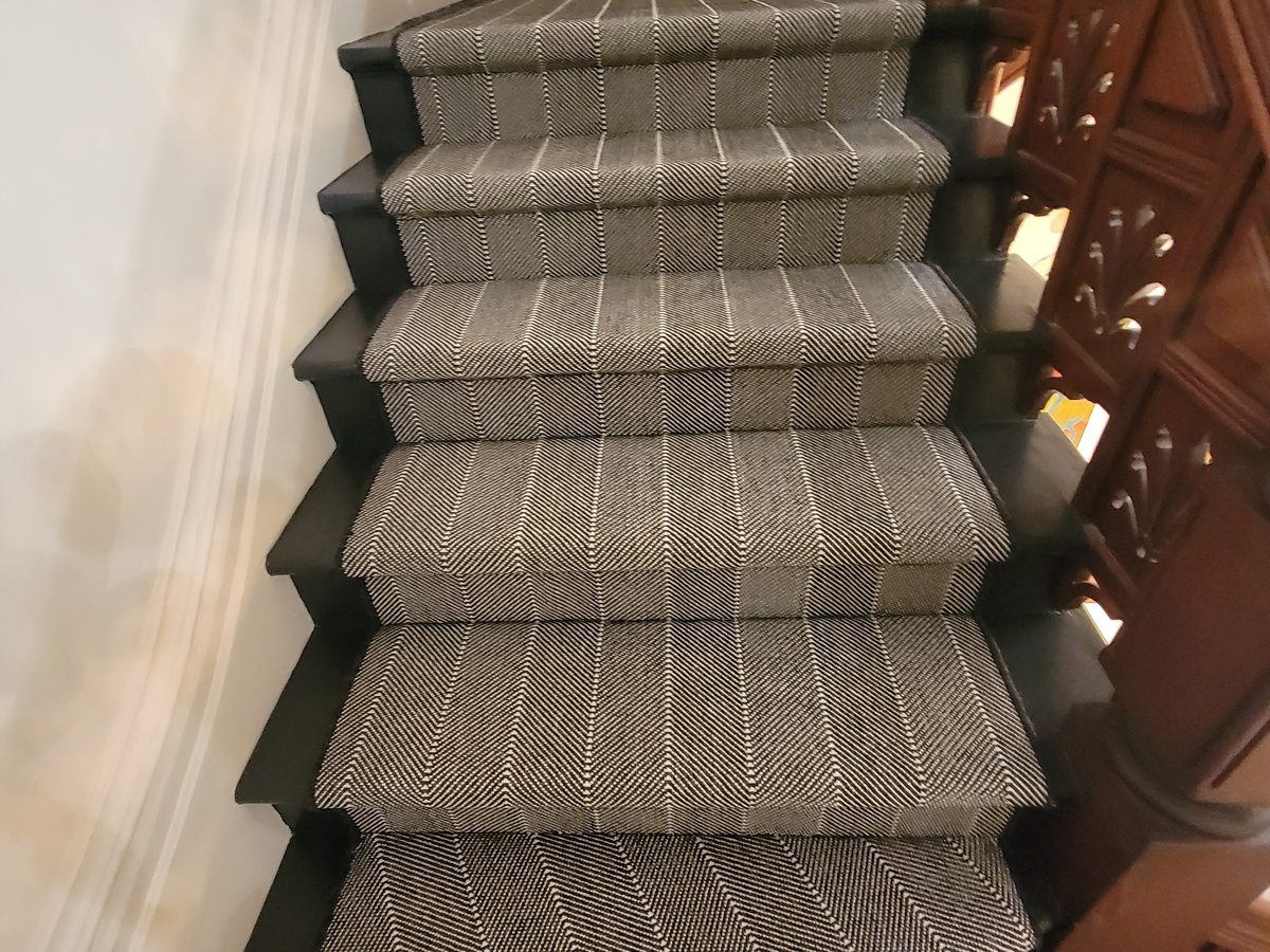 Grey patterned stair runner in a traditional wood stairwell